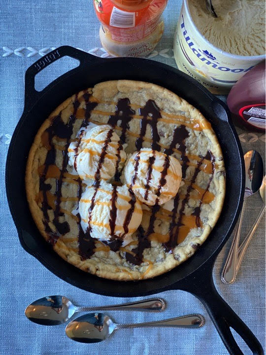 Skillet chocolate chip cookie fresh off the grill and topped with the essentials.