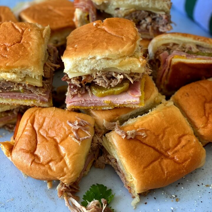Smoky Cuban sliders stacked on a cutting board.