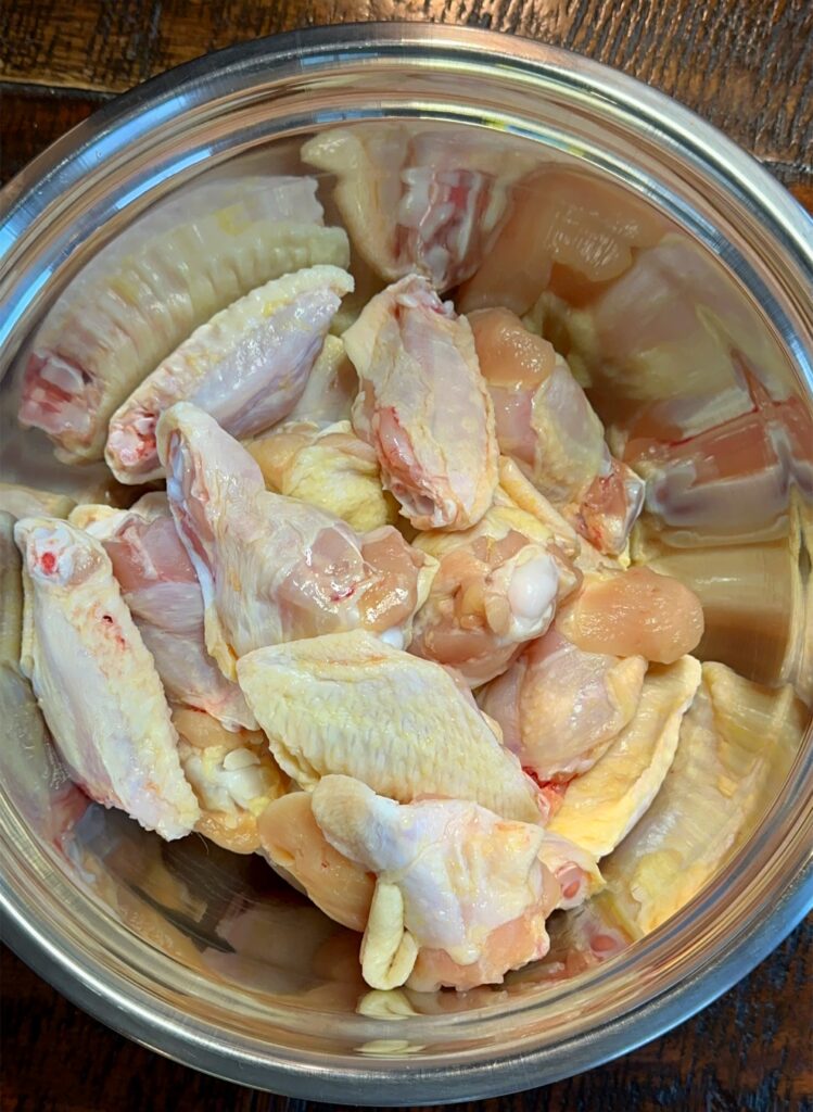 Drums and flats of chicken wings in a medium-sized mixing bowl.