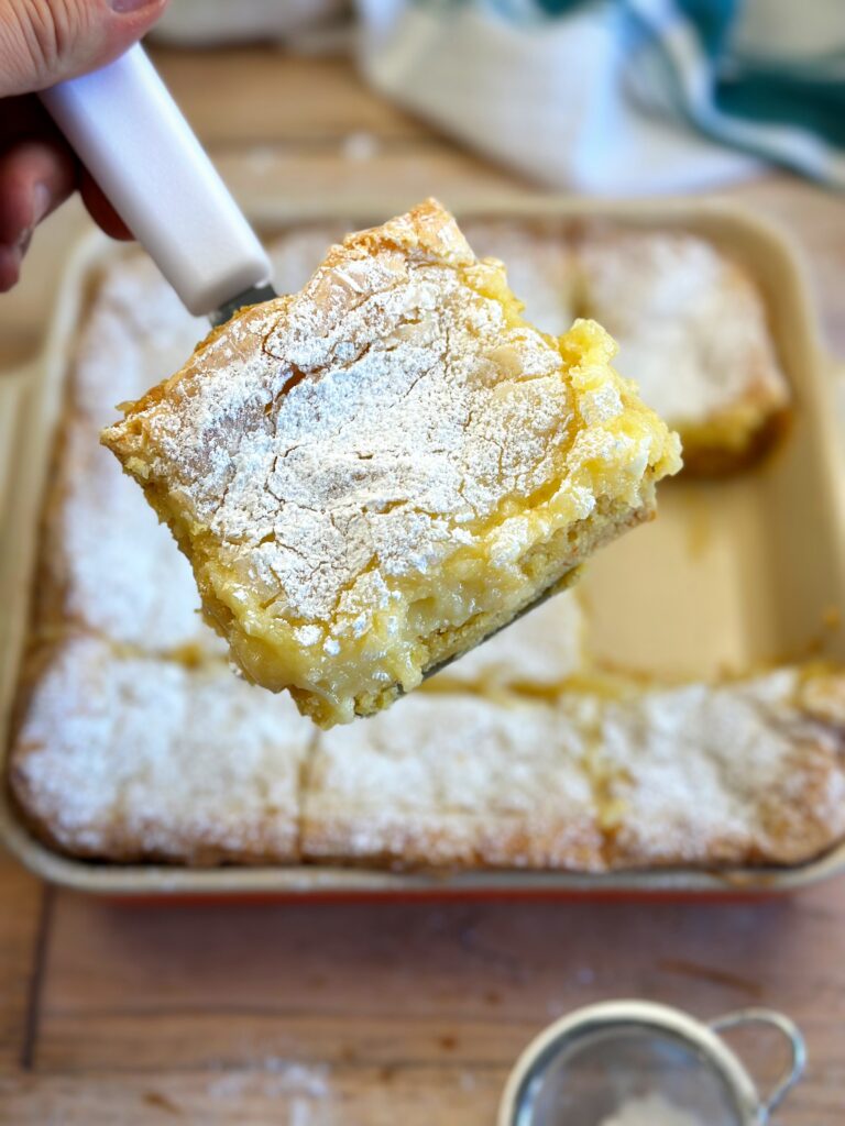 Ooey Gooey butter cake getting served up on a brownie spatula. 