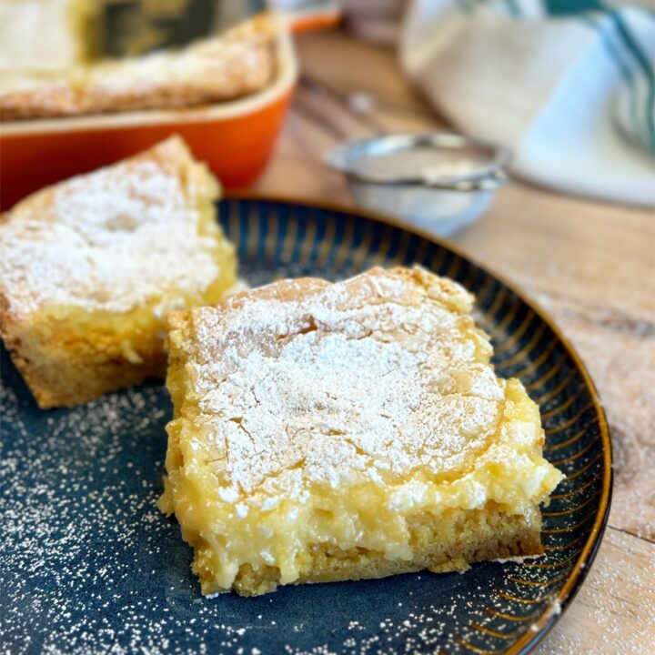 Squares of gooey butter cake on a plate.