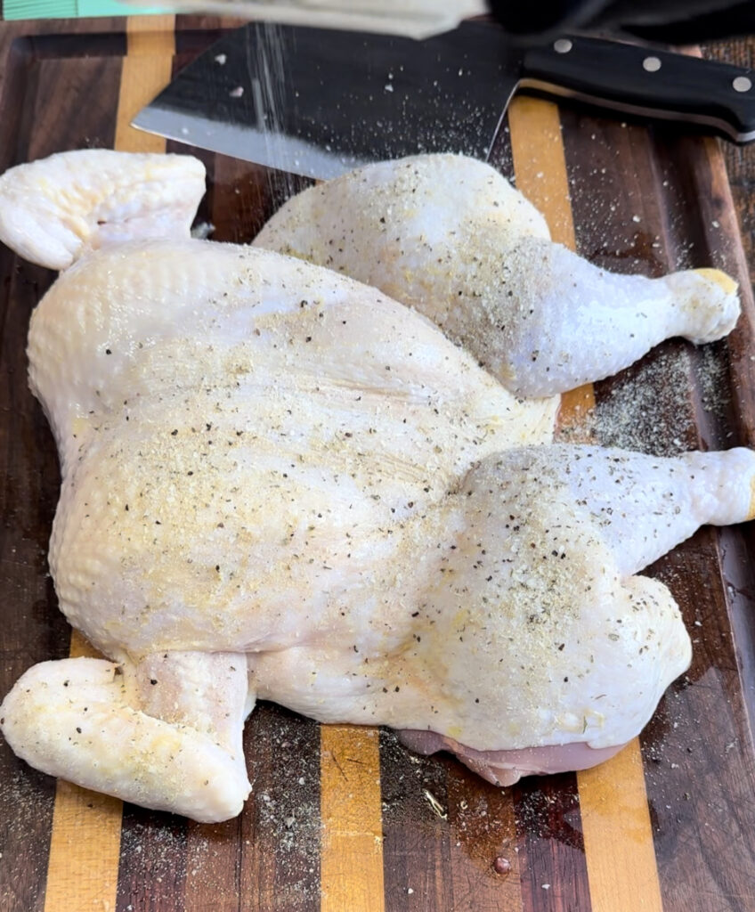 Chicken being seasoned after olive oil was applied.