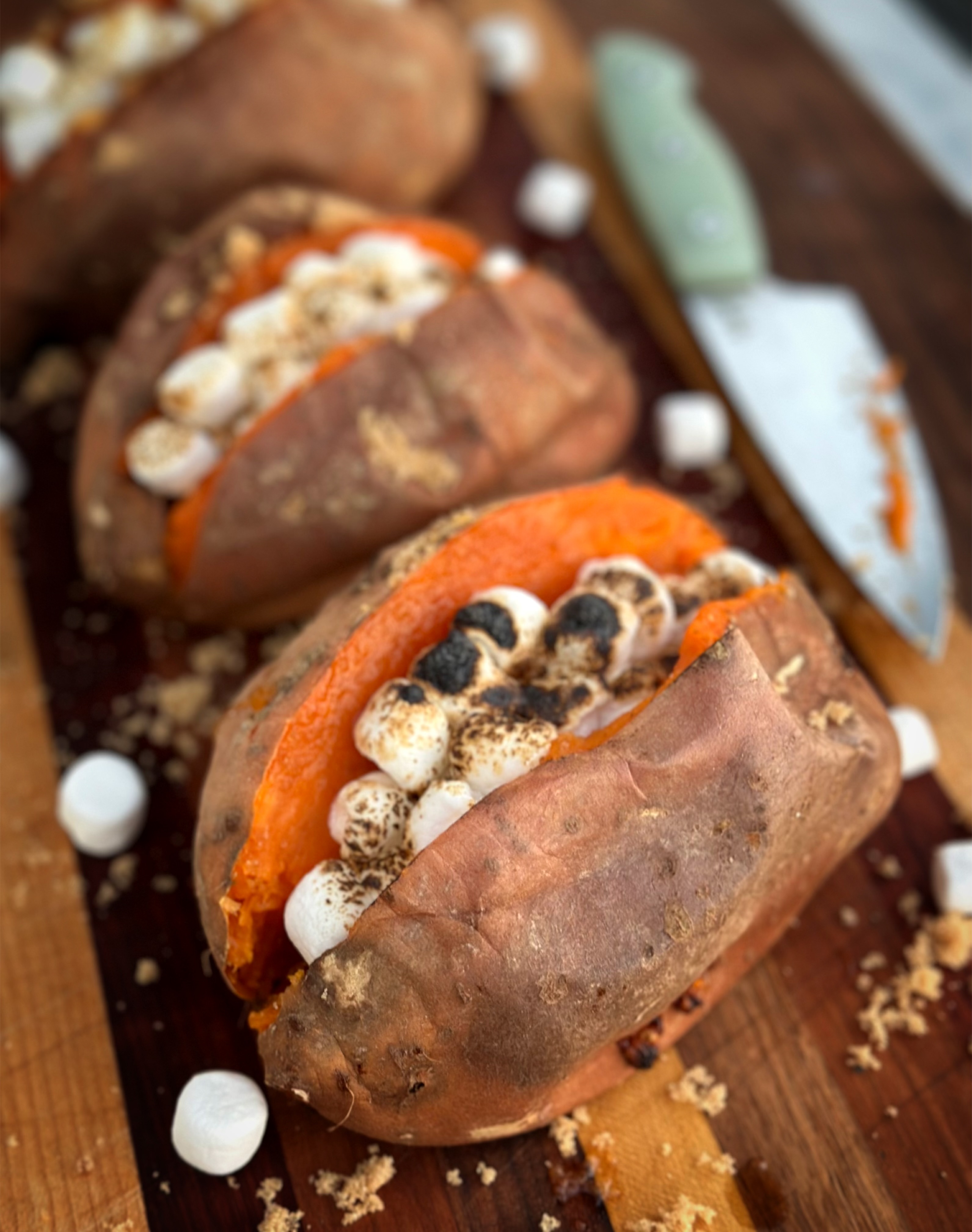 Grilled sweet potatoes are the perfect Thanksgiving side dish! Topped with toasted marshmallows in this image. 