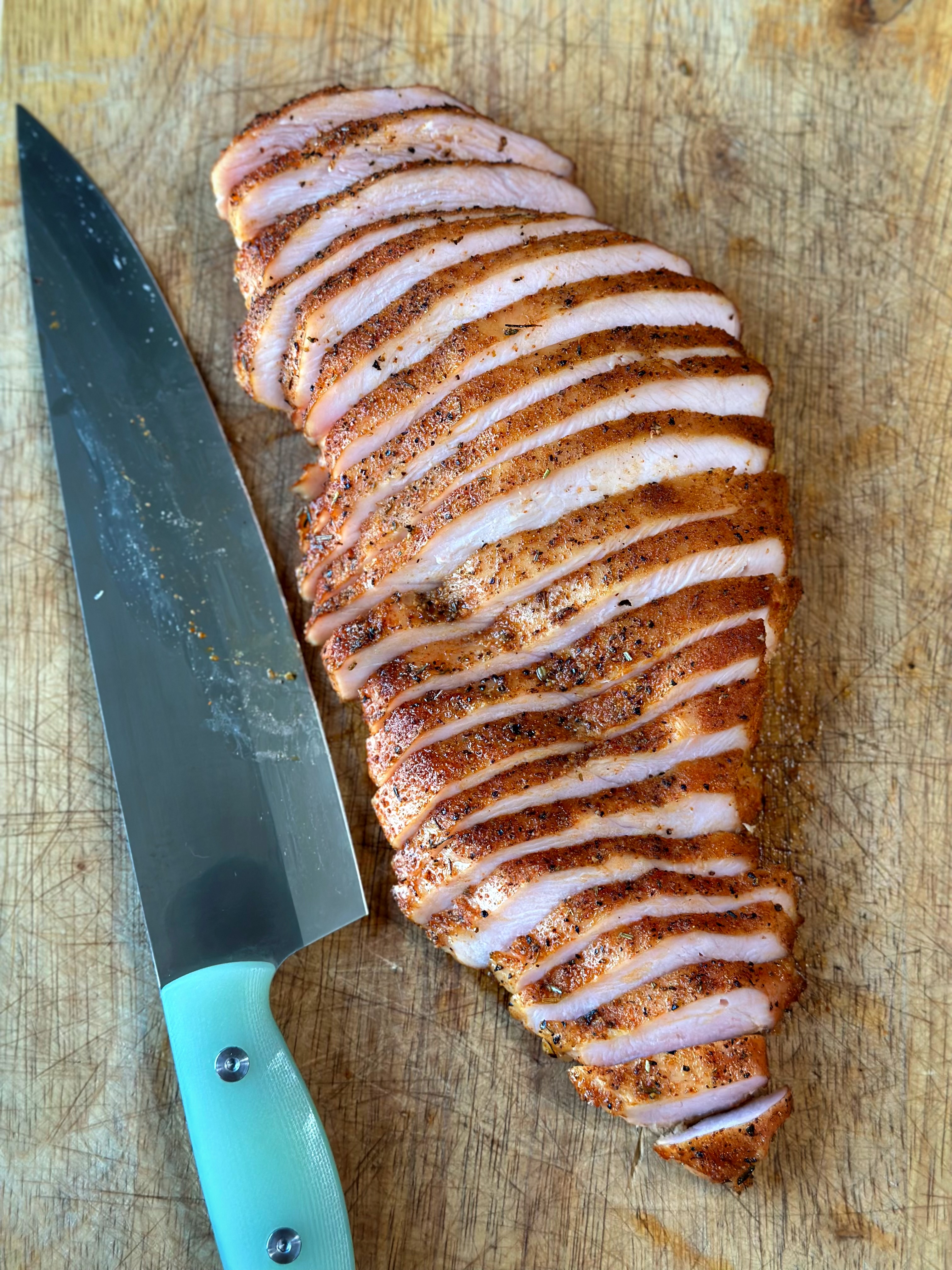 Thinly sliced smoked turkey breast on the cutting board. 