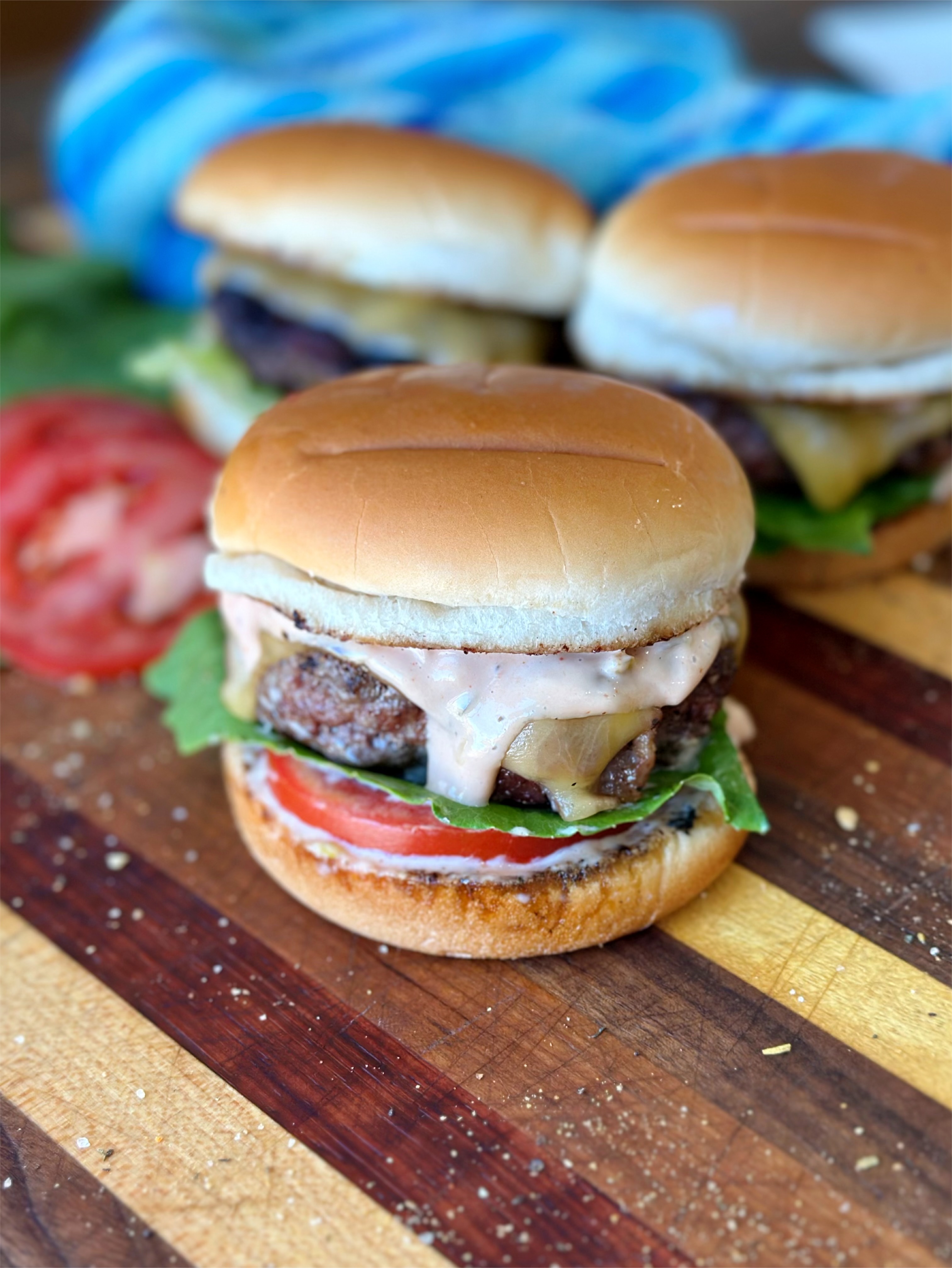 Burger recipe and burger sauce come together on a bun with lettuce and tomato. 