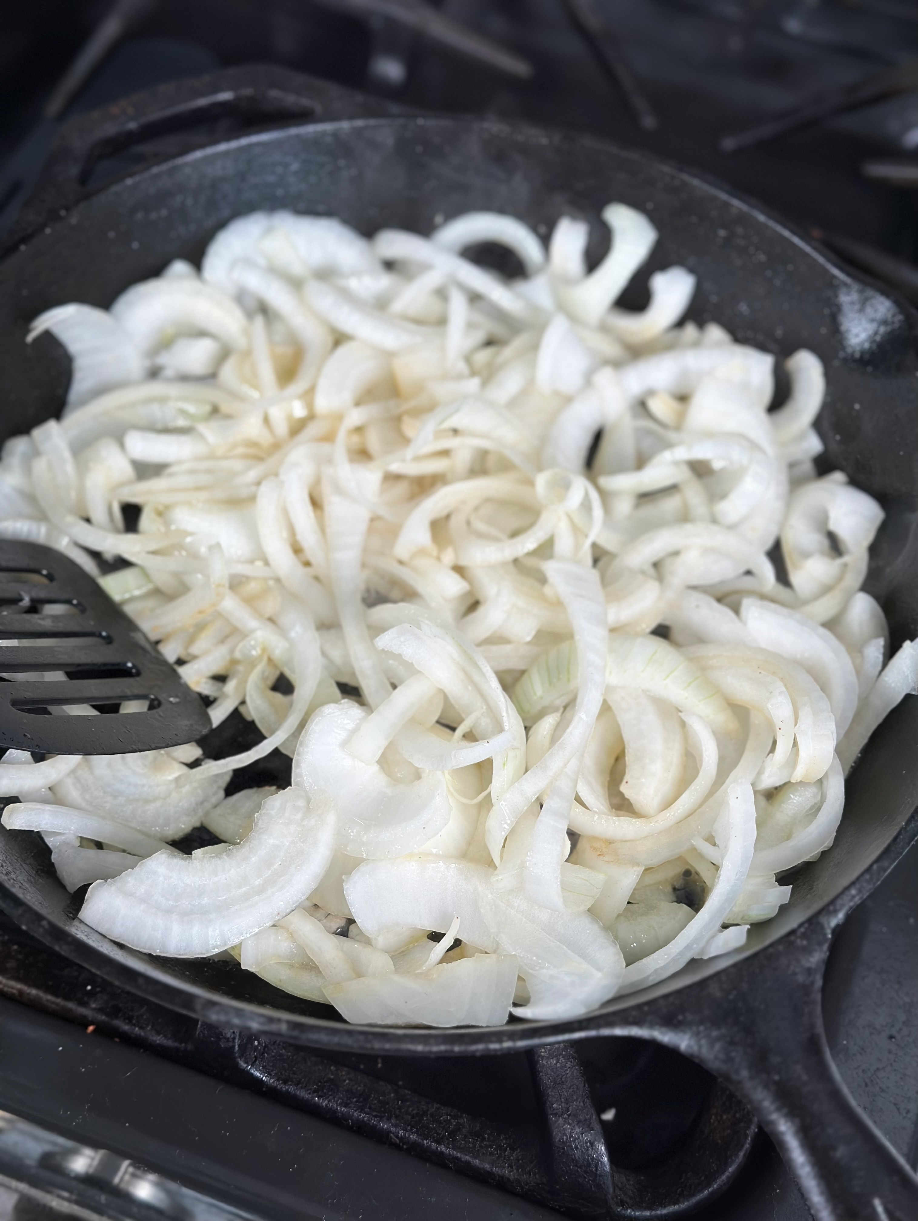 Sliced onions hitting the skillet. 